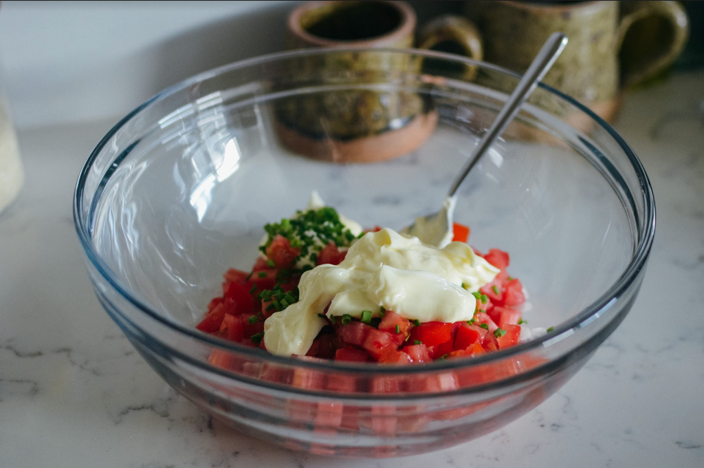 Simple Southern Cracker Salad Recipe- diced tomato, chopped chives, and mayonnaise in glass mixing bowl