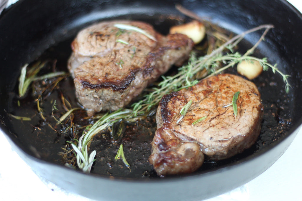 steak, garlic, and thyme in skillet