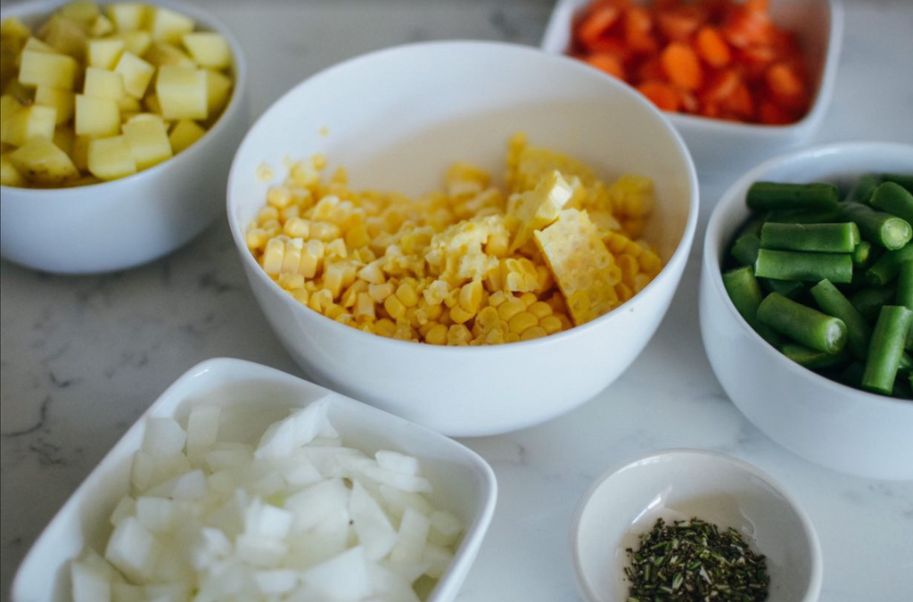 cut ingredients: carrots, green beans, onion, corn, and potatoes