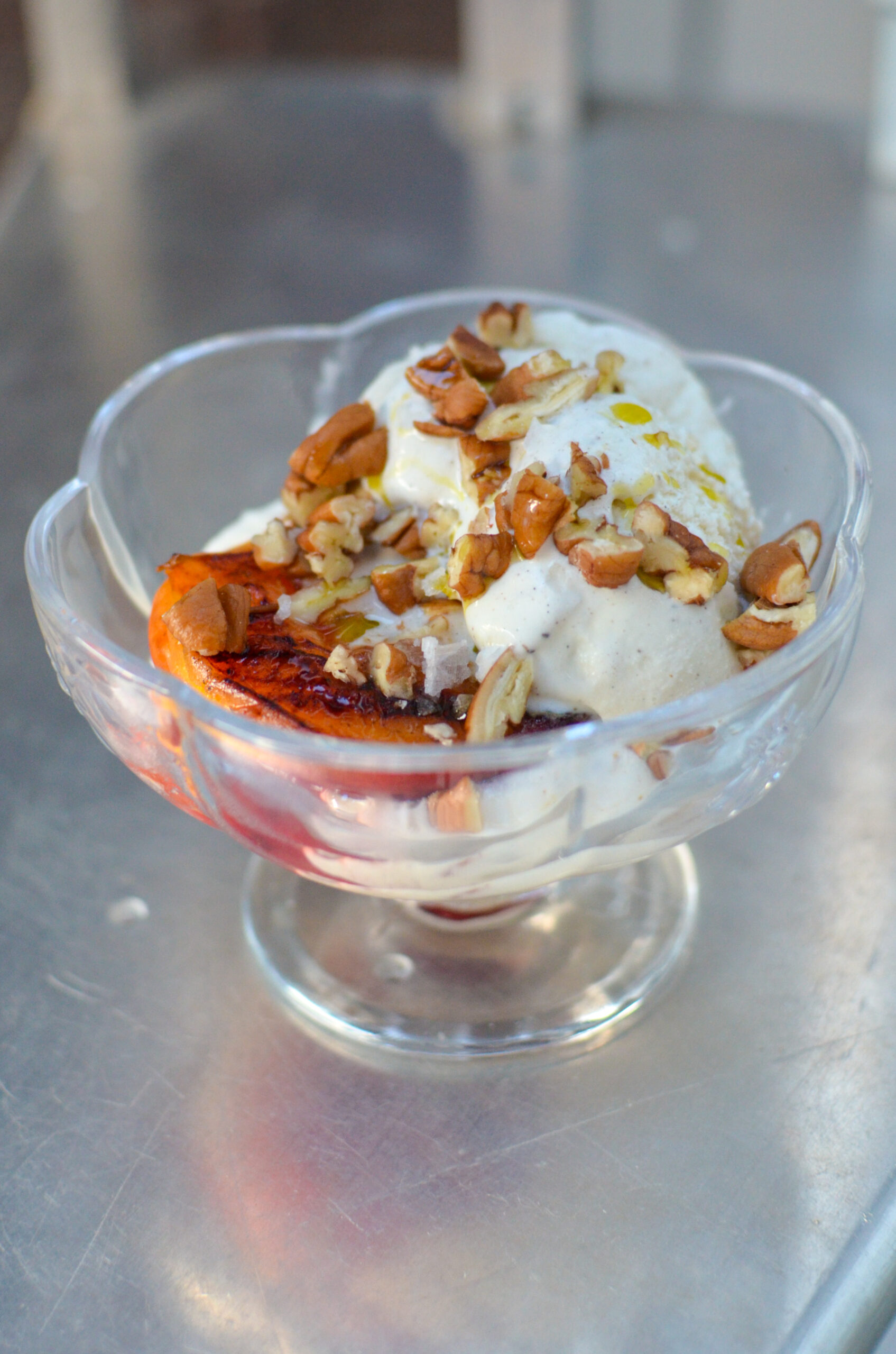 Grilled peaches paired with smooth vanilla ice cream, creating a dessert that screams sunshine and happiness.